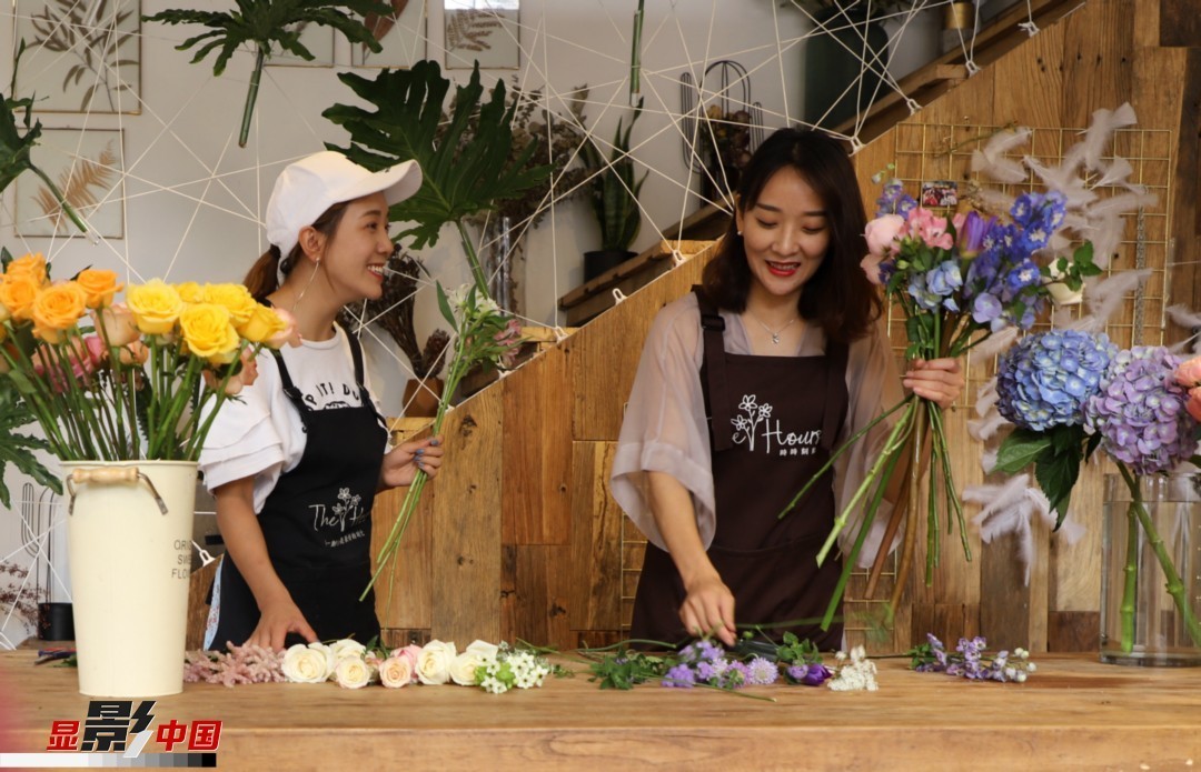 “昆明是鮮花的原產(chǎn)地，有亞洲最大的鮮切花交易市場，可以說具備開花店的天時地利；另外和很多女孩一樣，我從小也就有開花店的夢想！”說起當(dāng)初的決定，王黎媛說一是因?yàn)閴粝?，另外也跟昆明這個城市產(chǎn)花、賣花的“基因”有關(guān)。圖為王黎媛和同事在制作花束。新華網(wǎng) 周亞平/攝 念新洪/文